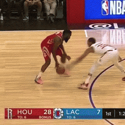 A Basketball Player Is Dribbling The Ball While Another Player Tries To Block Him . GIF
