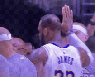 A Basketball Player Is Giving A High Five To His Teammate . GIF