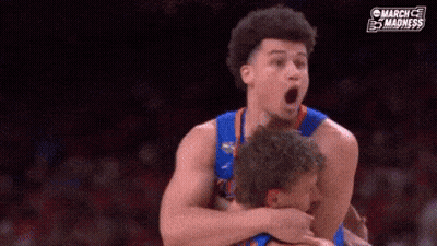 A Basketball Player Is Hugging Another Player With His Mouth Open During A Game . GIF
