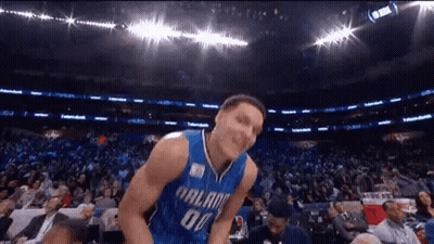 A Basketball Player Is Jumping In The Air In Front Of A Crowd . GIF