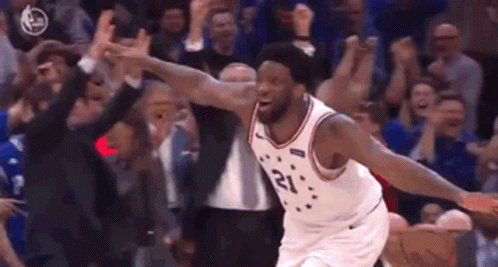 A Basketball Player Is Jumping In The Air In Front Of A Crowd Of People . GIF