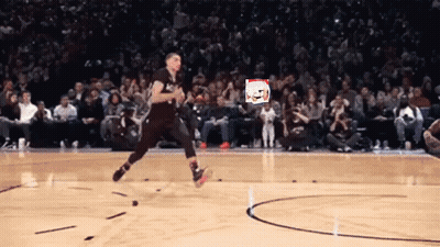 A Basketball Player Is Jumping In The Air On A Court With A Crowd Watching GIF