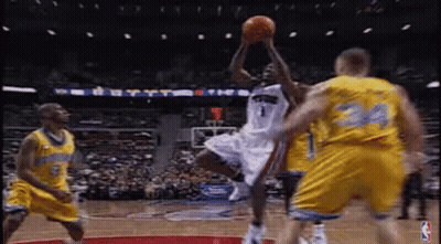 A Basketball Player Is Jumping In The Air To Catch A Basketball While Playing Basketball . GIF