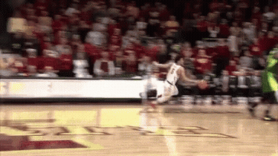 A Basketball Player Is Jumping In The Air While Dribbling The Ball GIF