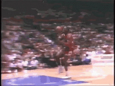 A Basketball Player Is Jumping In The Air While Holding A Basketball In His Hand . GIF