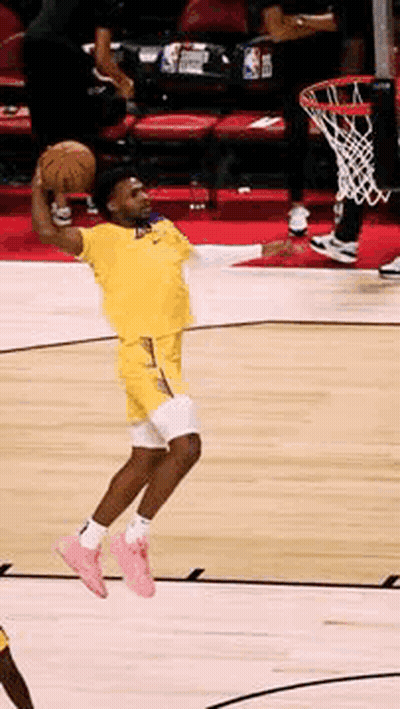 A Basketball Player Is Jumping In The Air While Holding The Ball GIF