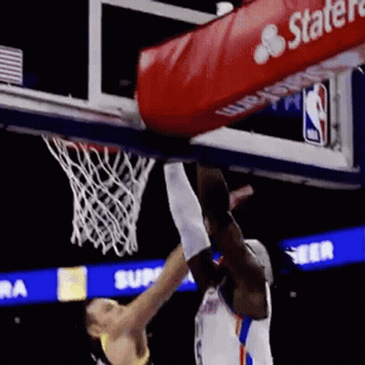 A Basketball Player Is Jumping Over Another Player Who Is Trying To Dunk The Ball . GIF