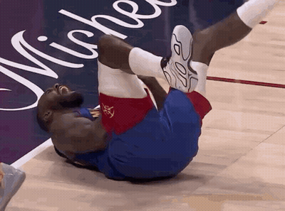 A Basketball Player Is Laying On His Back On The Court GIF