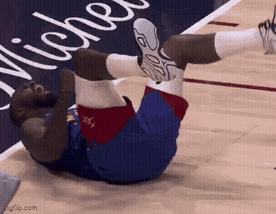 A Basketball Player Is Laying On His Stomach On The Court . GIF