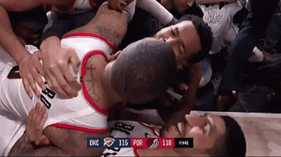 A Basketball Player Is Laying On The Floor Surrounded By Fans During A Game Against Okc GIF