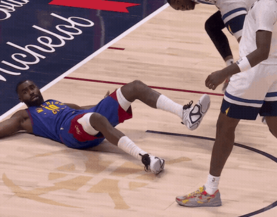 A Basketball Player Is Laying On The Floor With A Michelab Sign In The Background GIF