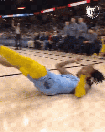 A Basketball Player Is Laying On The Floor With His Legs Up GIF
