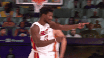 A Basketball Player Is Pointing At The Audience While Wearing A Jersey That Says Heat GIF