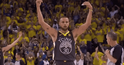 A Basketball Player Is Raising His Arms In The Air In Front Of A Crowd Of Fans . GIF