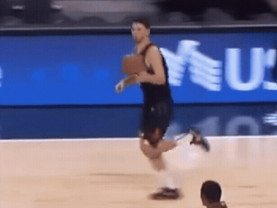 A Basketball Player Is Running On The Court In Front Of A Sign That Says U GIF