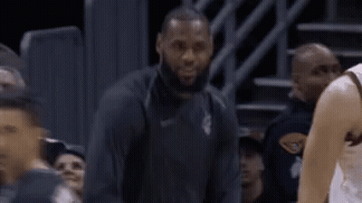 A Basketball Player Is Sitting On The Bench During A Game While Another Player Looks On . GIF