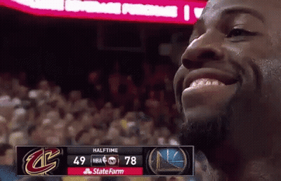 A Basketball Player Is Smiling In Front Of A Scoreboard That Says Halftime On It GIF