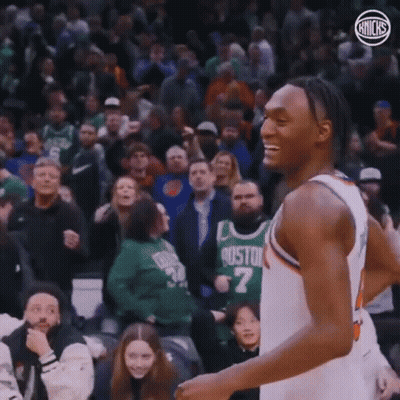 A Basketball Player Is Smiling While Standing In Front Of A Crowd At A Basketball Game . GIF