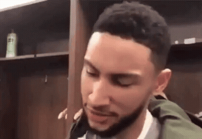 A Basketball Player Is Standing In A Locker Room With His Eyes Closed . GIF
