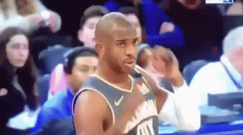A Basketball Player Is Standing In Front Of A Crowd During A Game And Making A Funny Face . GIF