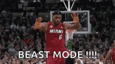 A Basketball Player Is Standing In Front Of A Crowd On A Basketball Court With His Hands In The Air . GIF