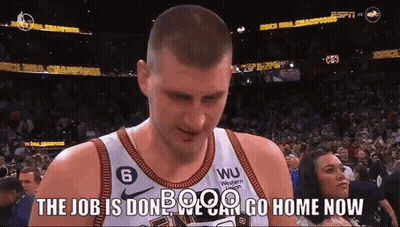 A Basketball Player Is Standing In Front Of A Crowd With A Woman Watching . GIF