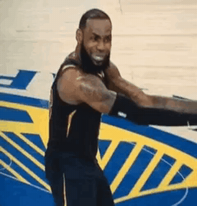 A Basketball Player Is Standing On A Basketball Court With His Arms Outstretched And Smiling . GIF