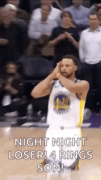 A Basketball Player Is Standing On A Court With His Hands On His Head And A Crowd Behind Him . GIF