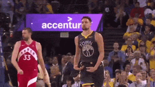 A Basketball Player Is Standing On The Court In Front Of A Crowd While Another Player Stands Behind Him . GIF