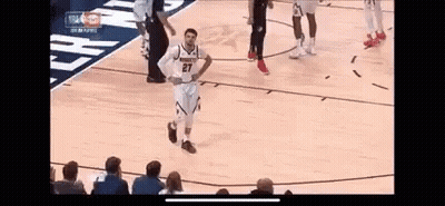 A Basketball Player Is Standing On The Court With His Hands On His Hips During A Game . GIF
