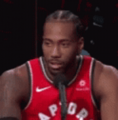 A Basketball Player Is Talking Into A Microphone . GIF