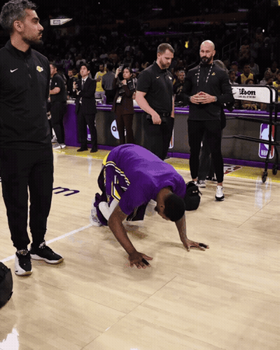 A Basketball Player Kneeling Down On The Court With A Sign That Says Ibon GIF