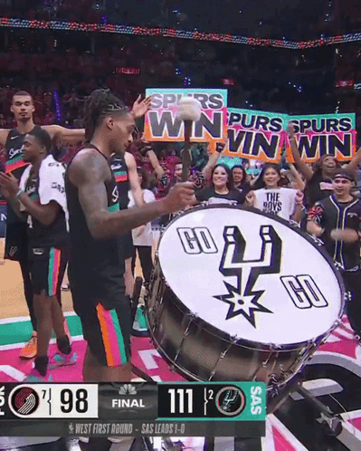 A Basketball Player Playing A Drum With A Banner That Says " Spurs Win Win Win " GIF
