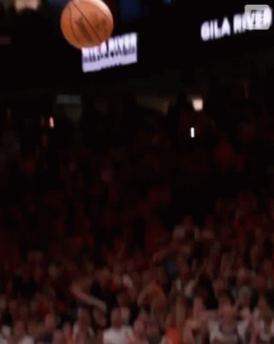 A Basketball Player Reaches For A Trophy In Front Of A Sign That Says Gala River Hot Casinos GIF