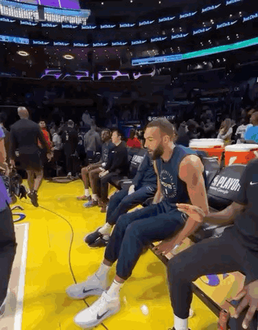 A Basketball Player Sits On A Bench During A Game GIF
