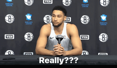 A Basketball Player Sitting At A Table With A Microphone In Front Of A Wall That Says Yes GIF