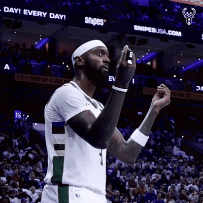 A Basketball Player Stands In Front Of A Sign That Says Snipes On It GIF