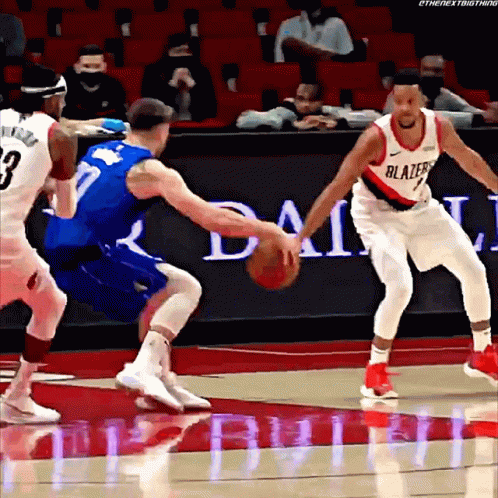 A Basketball Player Wearing A Blazers Jersey Is Dribbling The Ball GIF
