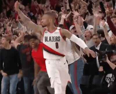 A Basketball Player Wearing A Blazers Jersey Stands In Front Of A Crowd Of People GIF