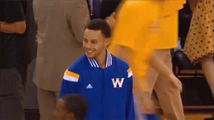 A Basketball Player Wearing A Blue And Yellow Jacket With The Letter W On It Is Smiling . GIF
