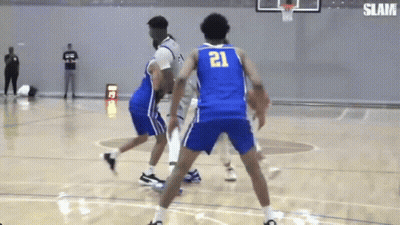 A Basketball Player Wearing A Blue Jersey With The Number 21 On It Is Dribbling The Ball . GIF