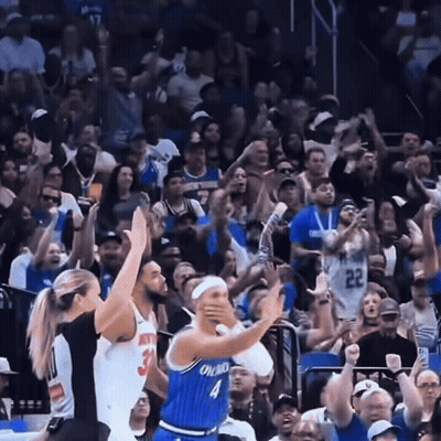 A Basketball Player Wearing A Blue Orlando Jersey Stands In Front Of A Crowd GIF