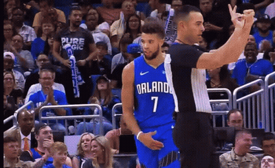 A Basketball Player Wearing A Blue Orlando Jersey Stands Next To A Referee GIF