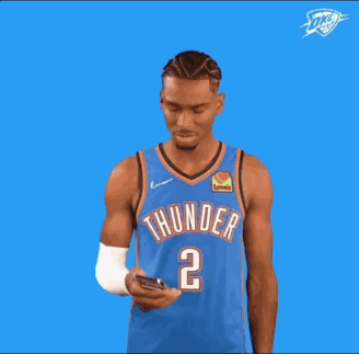 A Basketball Player Wearing A Blue Thunder Jersey Is Pointing Up . GIF