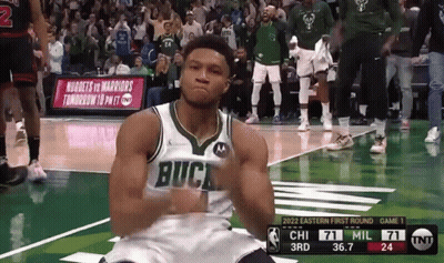 A Basketball Player Wearing A Buck Jersey Is Kneeling Down On The Court GIF