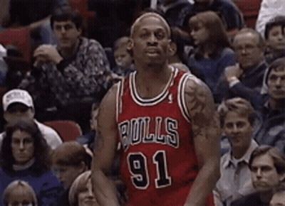 A Basketball Player Wearing A Bulls 91 Jersey Is Standing In Front Of A Crowd GIF