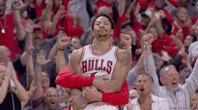 A Basketball Player Wearing A Bulls Jersey Is Being Held By A Fan GIF