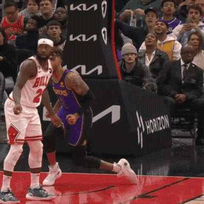 A Basketball Player Wearing A Bulls Jersey Runs Towards Another Player Wearing A Lakers Jersey GIF