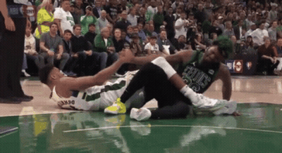 A Basketball Player Wearing A Celtics Jersey Is Laying On The Court GIF