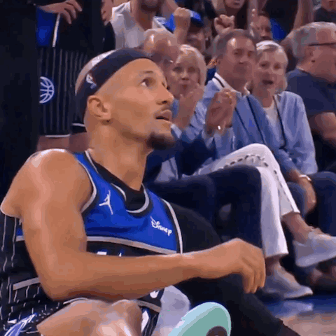 A Basketball Player Wearing A Disney Jersey Sits On The Bench GIF